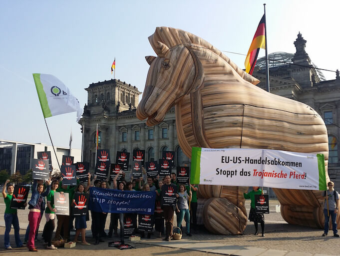 Der öffentliche Protest gegen die Handelsabkommen CETA und TTIP ist ungebrochen, wie hier bei einer Demo vor dem Bundestag im September 2014. Die Bürger fürchten sie als „trojanisches Pferd“, das die Demokratie untergraben könnte. (Foto: <a href="https://www.flickr.com/photos/mehr-demokratie/15233694766/in/photolist-pd9EHL-fKRMCW-aJJR7p-r2W6p9-iHZDQh-aJJRVF-sqBUrk-aJJPQt-pCbGL1-aJJNgc-aJJP4i-npq2SV-aJJLo2-nbqT7c-8WAtx6-p4Gn56-r3YZDq-nbqTft-r1LDaj-sc8XD8-aJJGVn-npGrUp-npJHX1-npq18T-nsXJrU-nrt4jB-na2vXR-n3R7ut-aJJMnT-sajvQ9-nqSU81-nEtmAx-ndS3DK-aJJSFB-rSRRDi-nscBjC-rUBNAU-8WAsCV-rUAJcU-nbqYkQ-nCteUh-sc8YMa-aJJHEk-nnDSyU-scEoPt-rfoiPH-zYBucC-pkHDFw-pkHCWA-sajvUh" target="_blank">Mehr Demokratie</a>)